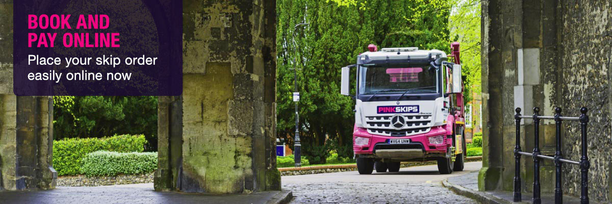 pink skip lorry approaching archway